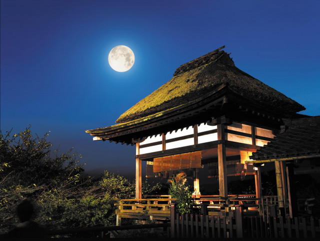 「石山寺と満月の夜景。かやぶき屋根の本堂が、夜空に輝く満月の光を浴び、幻想的な雰囲気を漂わせている。」