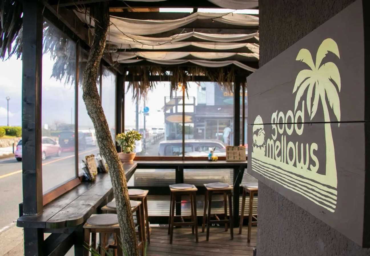  湘南・由比ヶ浜にあるハンバーガーカフェ「Good Mellows」の店先とテラス席。海沿いに位置し、サイクリング中の休憩に最適なローカル人気店。